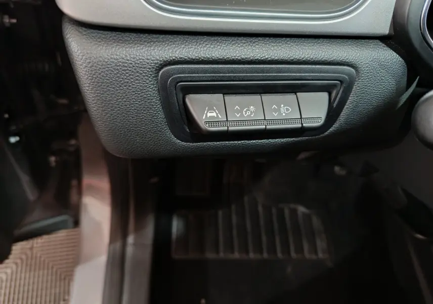 Gros plan sur les boutons de réglage des aides à la conduite et phares du Renault Captur gris foncé, côté conducteur.