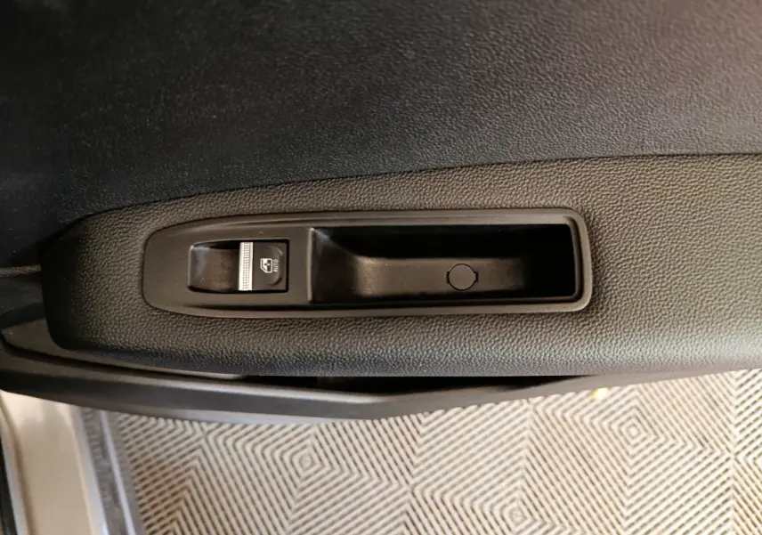 Bouton de commande de lève-vitre sur la porte côté gauche du Renault Captur gris foncé 2024.