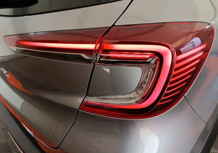 Gros plan sur le feu arrière droit allumé du Renault Captur gris foncé 2024, soulignant son design LED distinctif.
