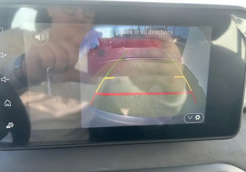 Écran tactile intérieur montrant la caméra de recul du Dacia Sandero III Stepway bleu Iron avec guidage coloré.