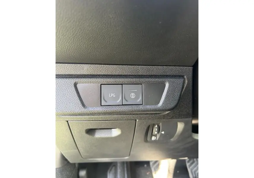 Détail intérieur montrant les boutons de commande LPG et verrouillage, sur tableau de bord noir du Dacia Sandero Stepway.