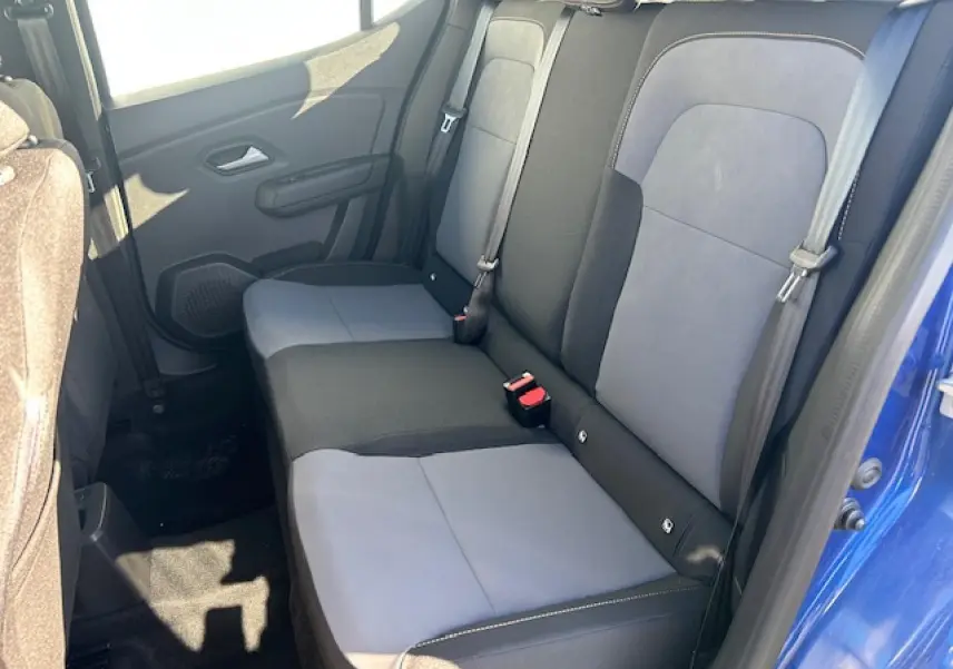 Vue intérieure côté droit de la banquette arrière bicolore gris et noir du Dacia Sandero III Stepway bleu Iron.