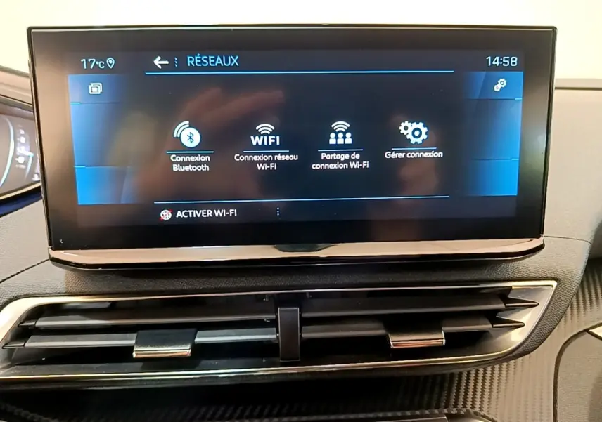 Écran tactile central affichant les options réseau Wi-Fi et Bluetooth dans l’habitacle d’un Peugeot 3008 gris foncé.