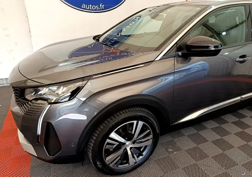 Peugeot 3008 BlueHDi 130 gris foncé en 3/4 avant droit, avec phares LED et jantes alliage visibles.