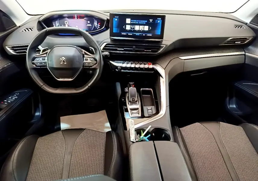 Vue intérieure avant du Peugeot 3008 2022 gris foncé, avec tableau de bord digital et écran tactile central.