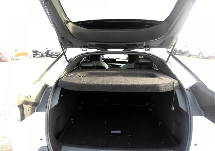 Vue arrière du coffre ouvert d'un Peugeot 3008 blanc, montrant l'espace de chargement et l'intérieur sombre.