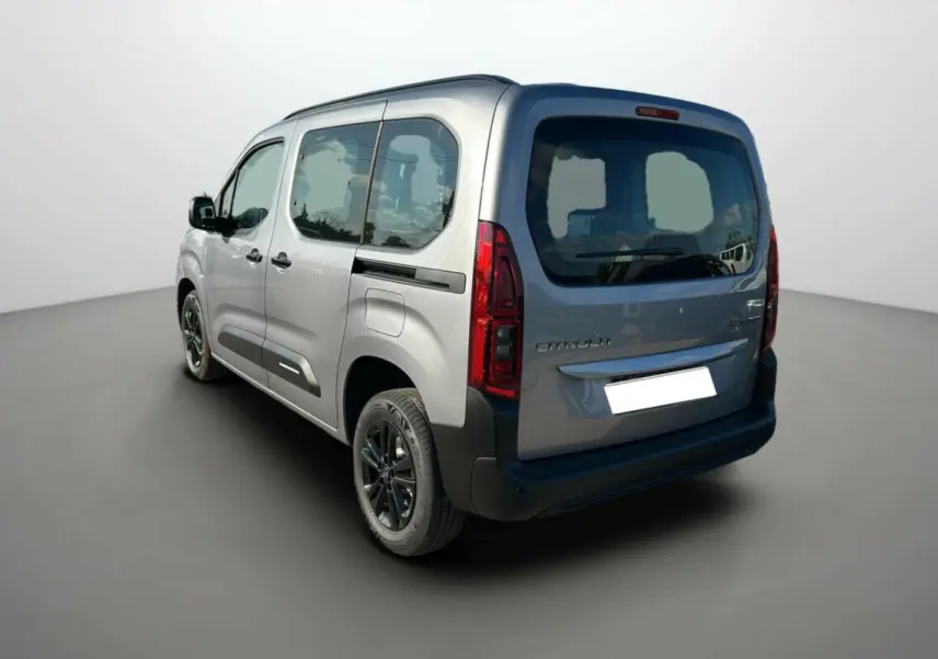 Vue 3/4 arrière gauche d'un Citroën Berlingo 2025 gris artense avec vitres teintées et jantes noires.