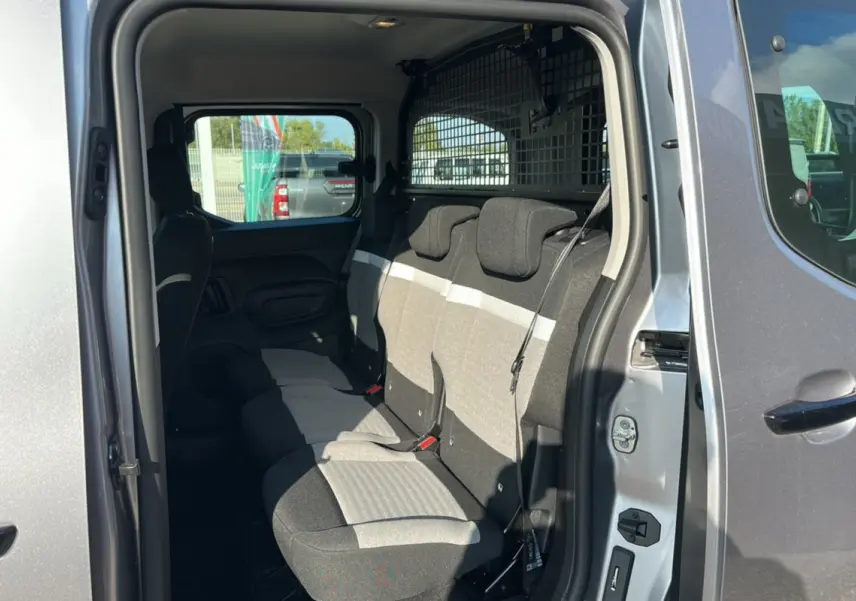 Intérieur arrière du Citroën Berlingo 2025 gris Artense, vue côté droit sur les sièges tissu bicolore et la grille de séparation.