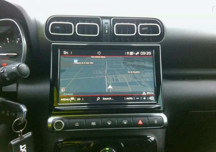 Vue rapprochée de l’écran tactile central et des commandes noires brillantes du tableau de bord du Citroën C3 Aircross noir.