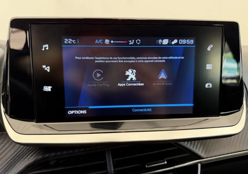 Écran tactile central affichant Apple CarPlay et Android Auto dans le tableau de bord noir d'une Peugeot 208 2021.