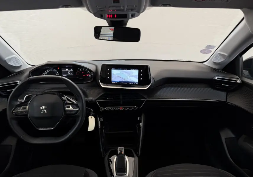 Intérieur noir de la Peugeot 208 PureTech 2021 vu de face, avec tableau de bord numérique et écran tactile central.