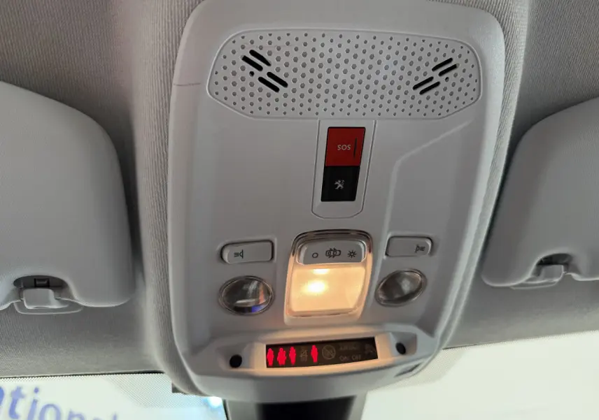 Plafonnier intérieur avec bouton SOS et éclairage, vue du toit d'une Peugeot 208 noire 2021 PureTech.