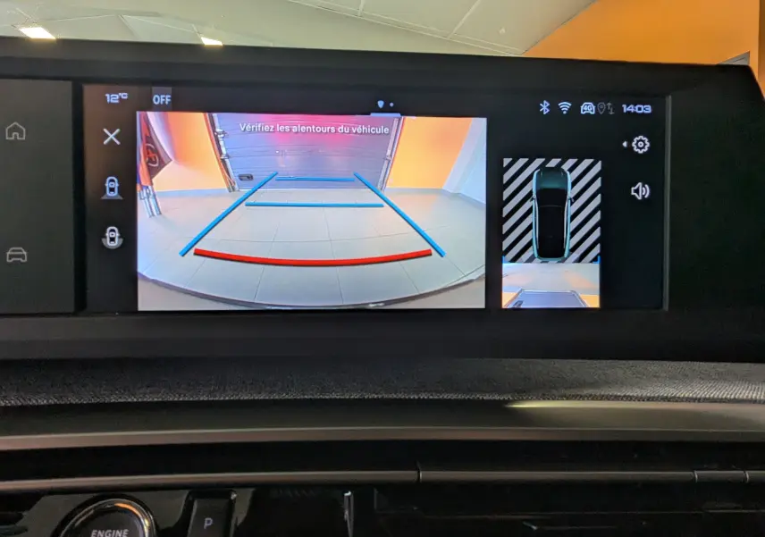 Écran central du Peugeot 3008 Hybrid blanc montrant la caméra de recul avec vue arrière et top view du véhicule.