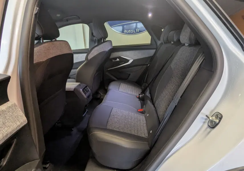 Vue intérieure côté droit sur les sièges arrière en tissu gris et cuir du Peugeot 3008 Hybrid blanc 2025.