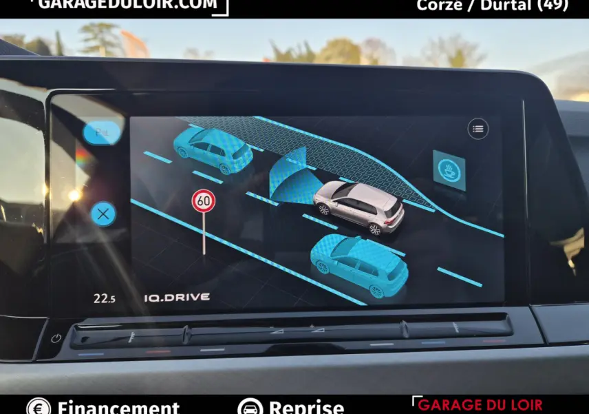 Affichage tactile intérieur de la Volkswagen Golf 2023 montrant l'assistance au maintien de voie et la détection des véhicules alentours.
