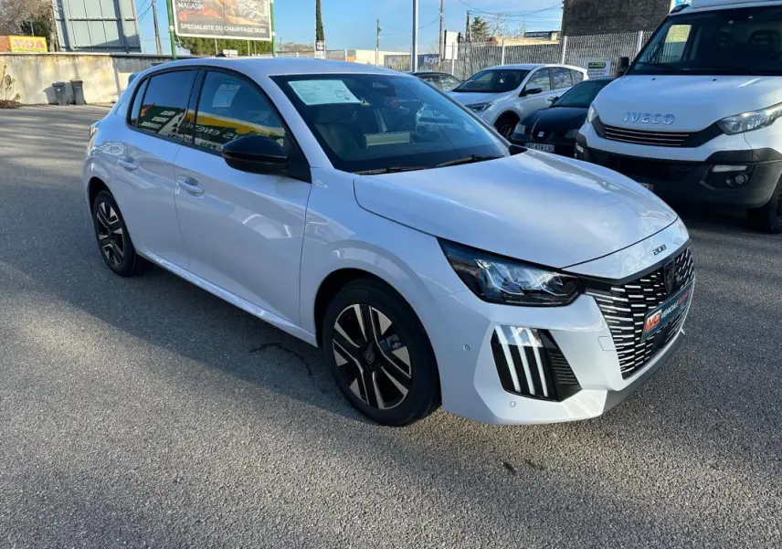 Peugeot 208 Hybrid blanc vue 3/4 avant droit, jantes alliage 16 pouces et calandre distinctive en extérieur.