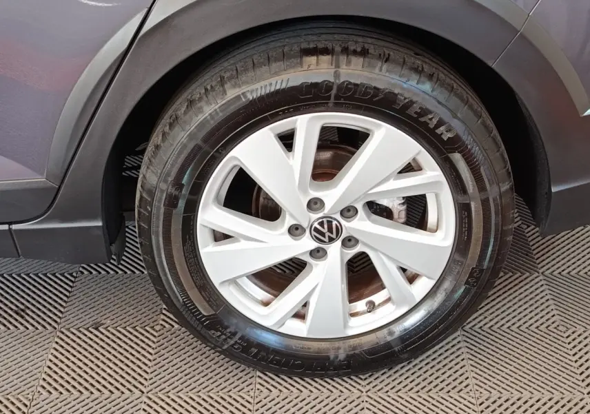 Gros plan sur la roue avant gauche grise foncée du Volkswagen Taigo 2023 avec jante alliage et logo VW au centre.
