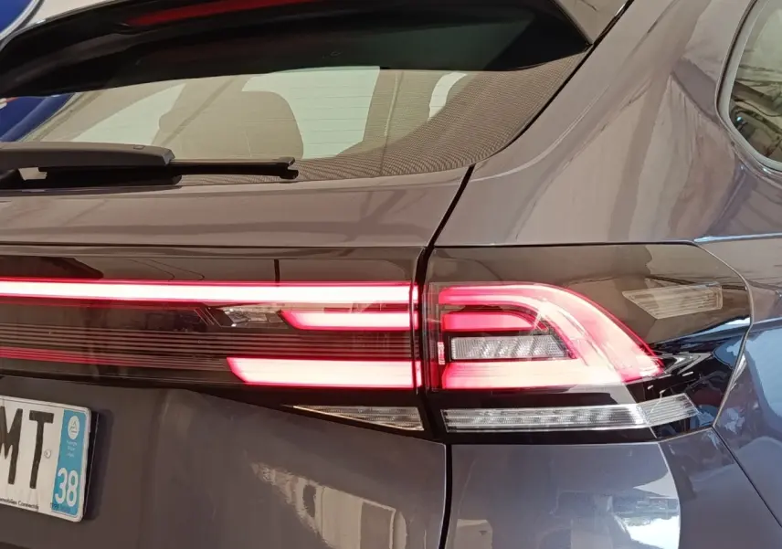 Feu arrière droit allumé d'un Volkswagen Taigo gris foncé, vue rapprochée de l'arrière du véhicule.
