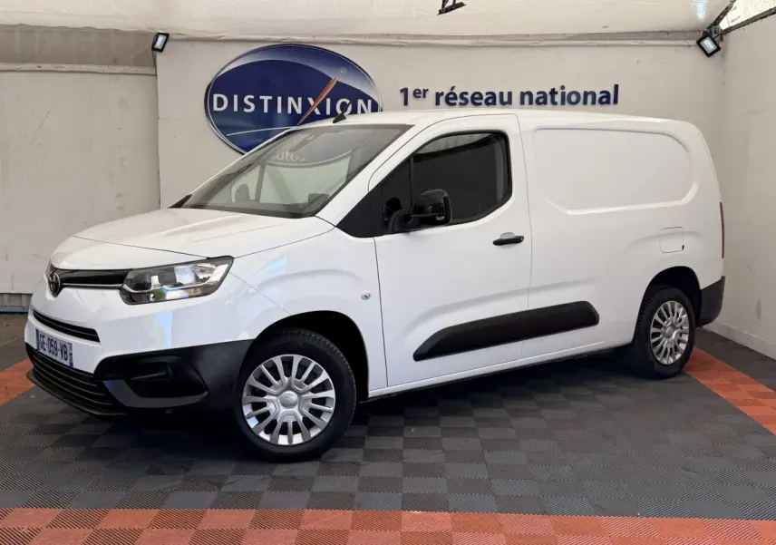 Vue 3/4 avant droit d'un Toyota Proace City blanc, fourgon utilitaire avec protections noires sur les bas de caisse et pare-chocs.