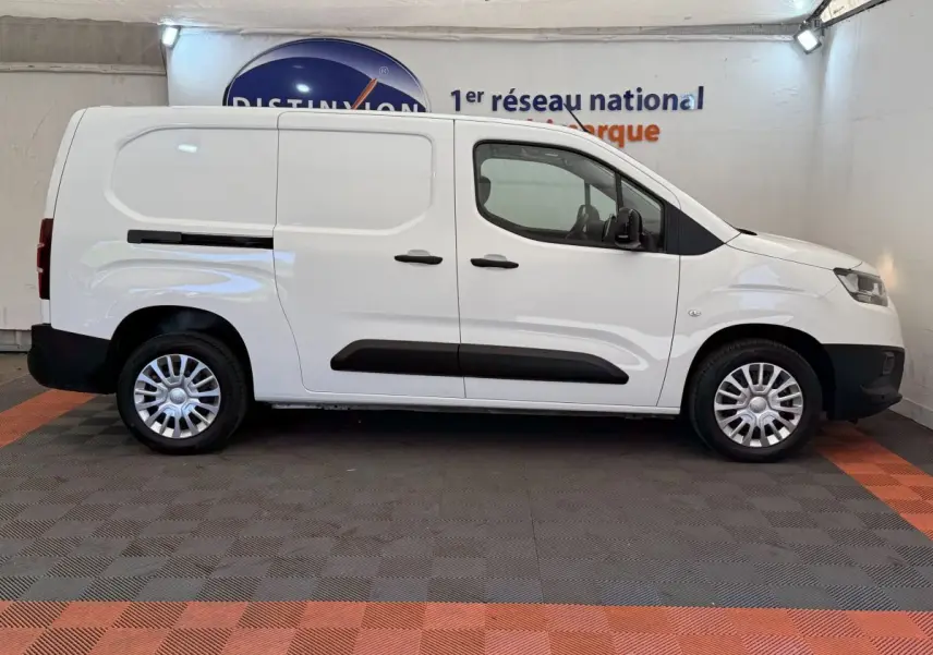 Vue de profil côté droit d'un Toyota Proace City blanc, fourgon utilitaire avec porte latérale coulissante et jantes acier.