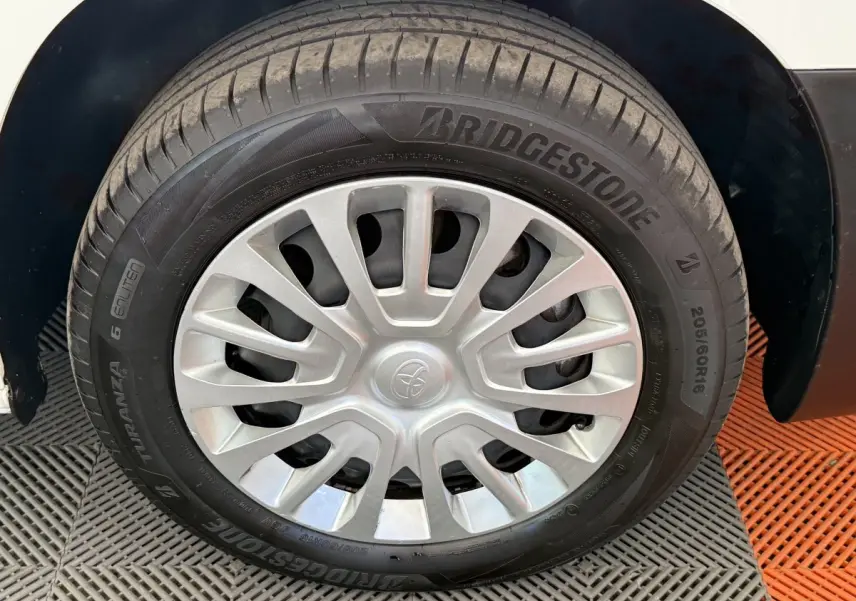 Gros plan sur la roue avant droite d’un Toyota Proace City blanc avec jante en acier et enjoliveur gris.