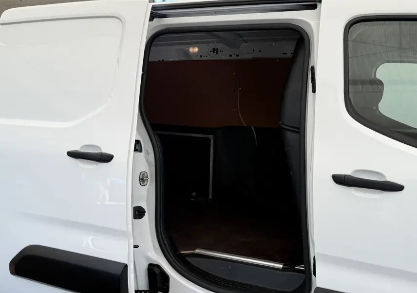 Vue latérale gauche sur la porte coulissante ouverte du Toyota Proace City blanc, montrant l’espace de chargement intérieur.