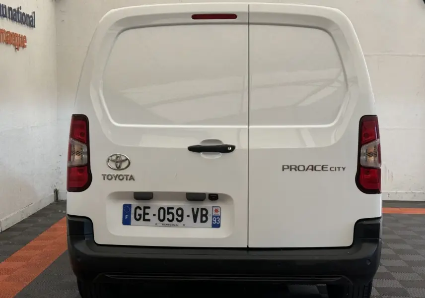 Vue arrière du Toyota Proace City blanc avec portes battantes et plaque d'immatriculation française visible.