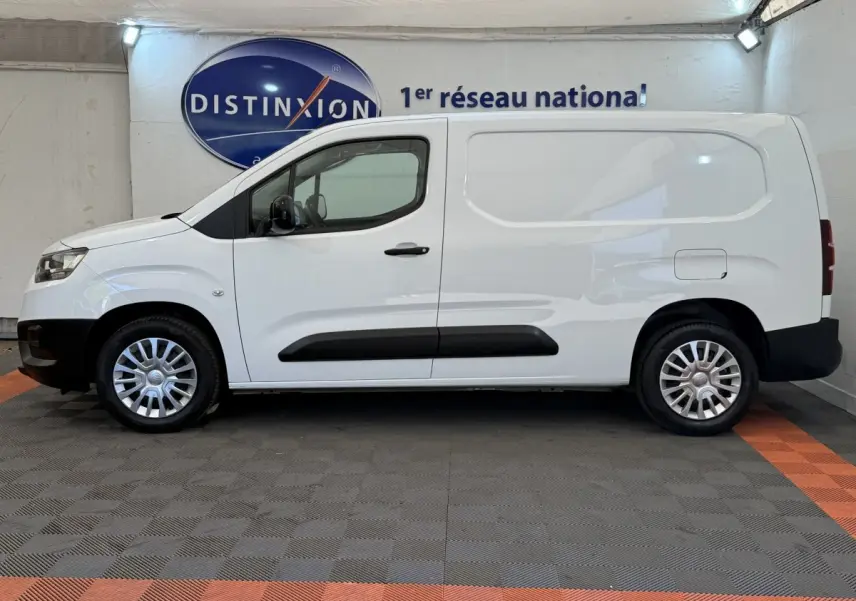 Vue de profil côté gauche du Toyota Proace City blanc, fourgon utilitaire avec jantes acier et protections noires.