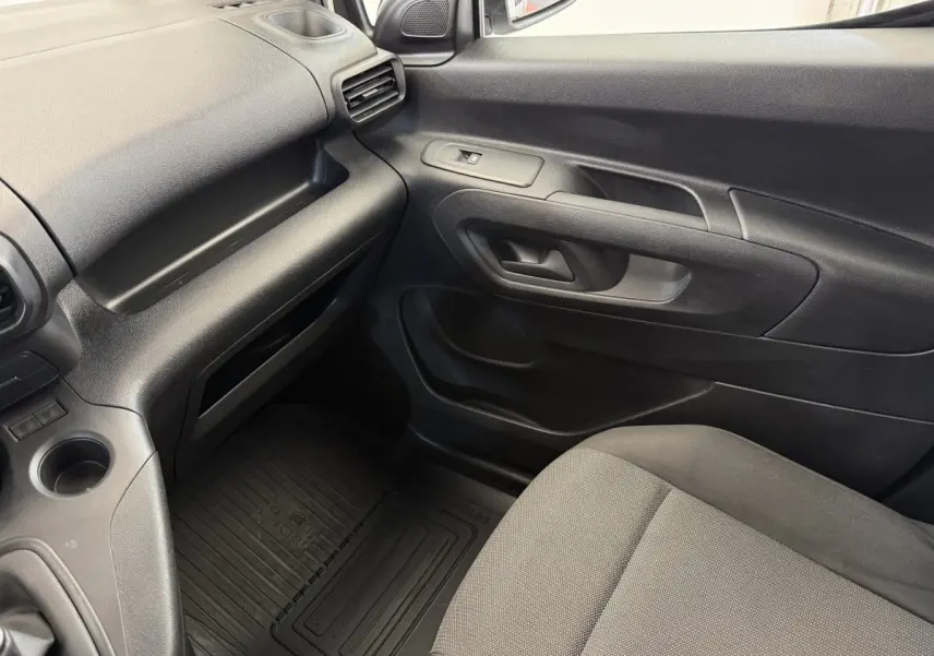Intérieur côté passager du Toyota Proace City 2022, avec tableau de bord et porte en plastique noir.
