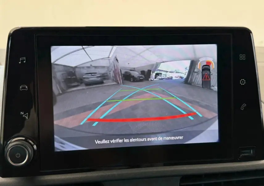 Écran tactile montrant la caméra de recul avec guidage et alertes de proximité du Toyota Proace City blanc.