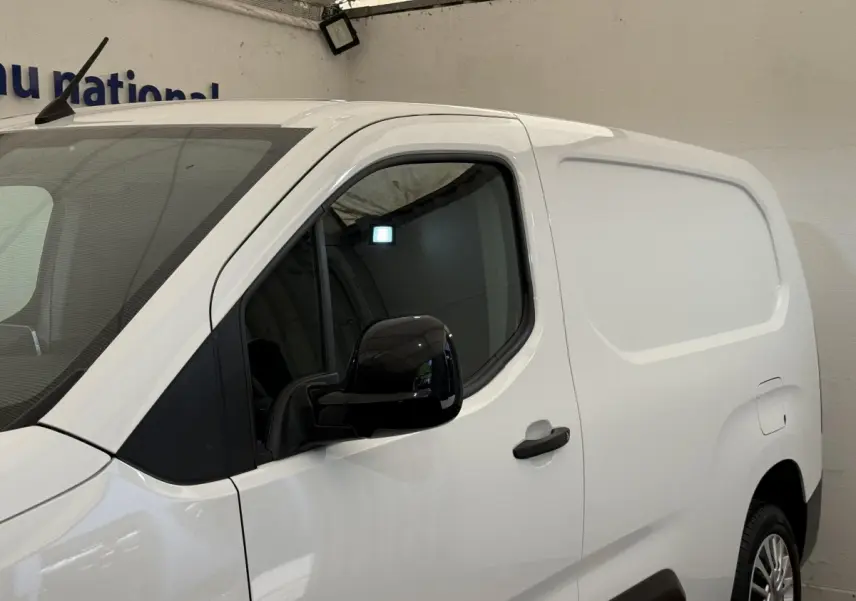 Vue de profil côté gauche d’un Toyota Proace City blanc, version utilitaire avec porte latérale pleine et rétroviseur noir.