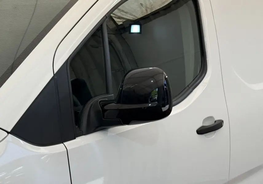 Vue rapprochée du côté gauche blanc du Toyota Proace City 2022, mettant en valeur le rétroviseur noir brillant et la poignée de porte.