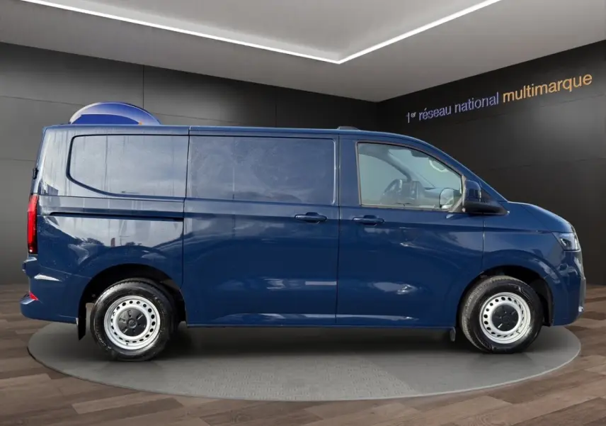 Vue de profil côté droit du Volkswagen Transporter bleu 2025, fourgon utilitaire avec jantes acier et vitres teintées.
