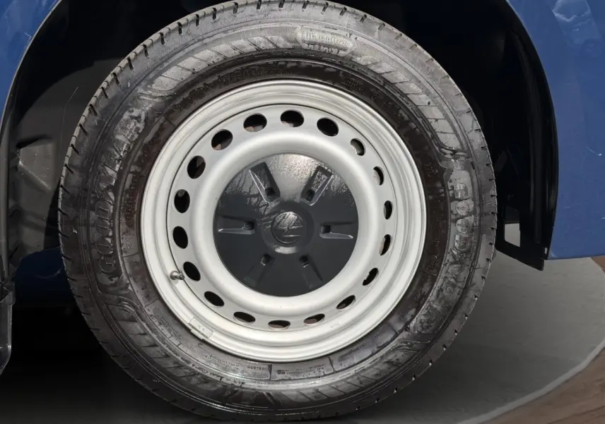 Gros plan sur la roue arrière droite en jante acier du Volkswagen Transporter bleu 2025.
