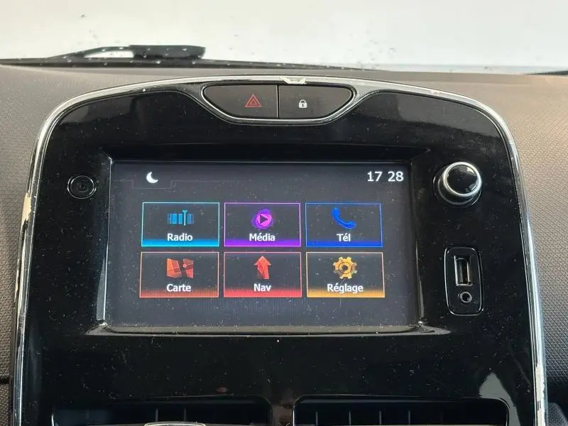 Écran tactile central de la Renault Clio gris platine 2014 affichant les options radio, média, téléphone, carte, navigation et réglages.