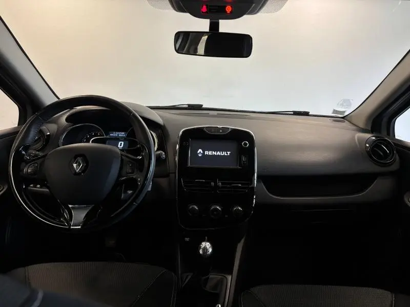 Vue intérieure avant de la Renault Clio 2014 avec tableau de bord noir et écran tactile central affichant le logo Renault