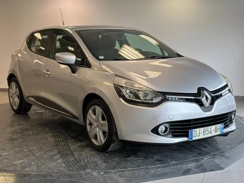 Renault Clio gris platine vue 3/4 avant droit, avec jantes alu et phares halogènes allumés