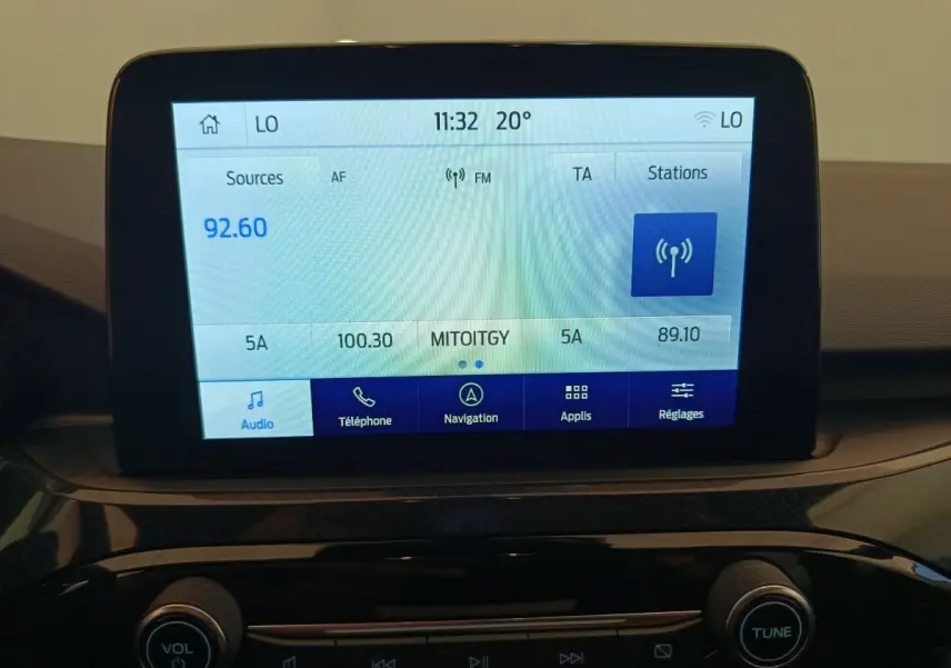 Écran tactile central affichant la radio et navigation dans le tableau de bord du Ford Kuga gris clair 2024.