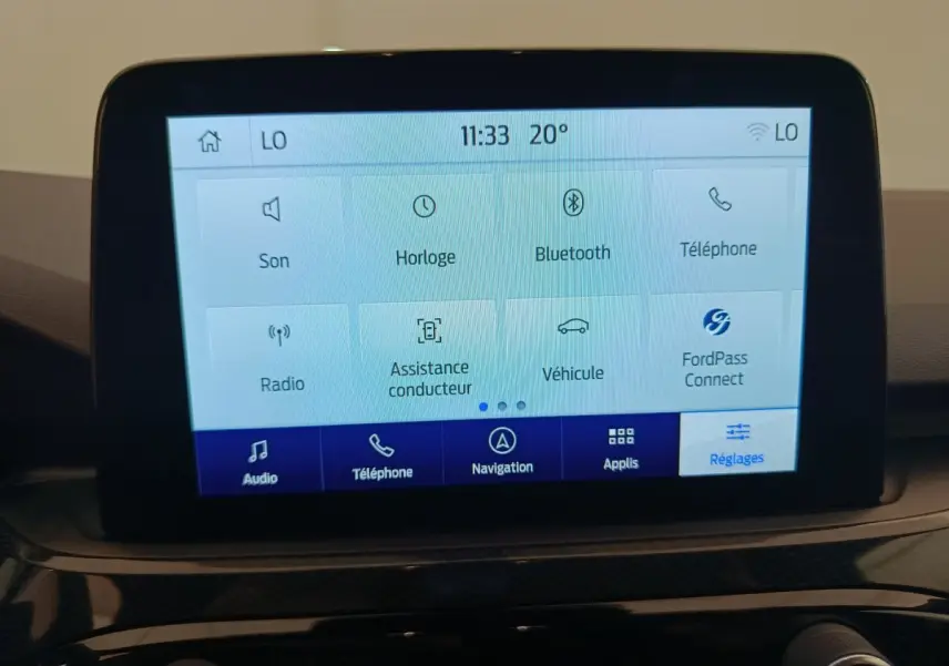 Écran tactile central du tableau de bord du Ford Kuga gris clair 2024 affichant les réglages et options connectées.