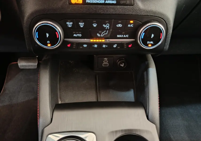 Vue rapprochée de la console centrale du Ford Kuga 2024, montrant les commandes de climatisation et ports USB.