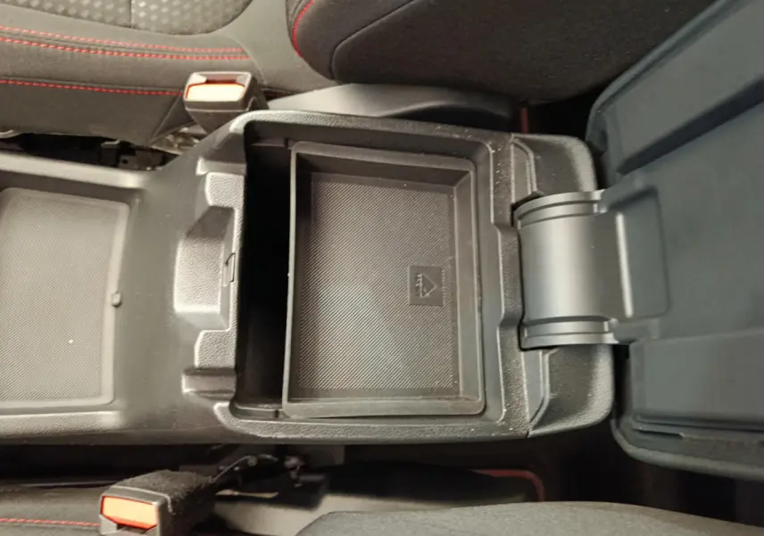 Coffre de console central ouvert avec rangement intérieur noir sur Ford Kuga gris clair 2024 St Line.