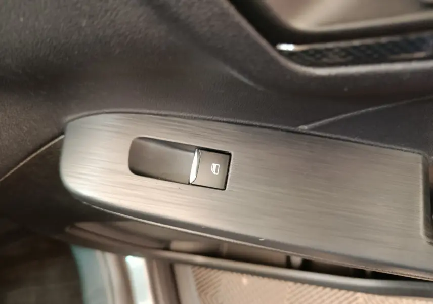 Bouton de commande de lève-vitre sur la porte intérieure côté conducteur du Ford Kuga gris clair 2024 St Line.