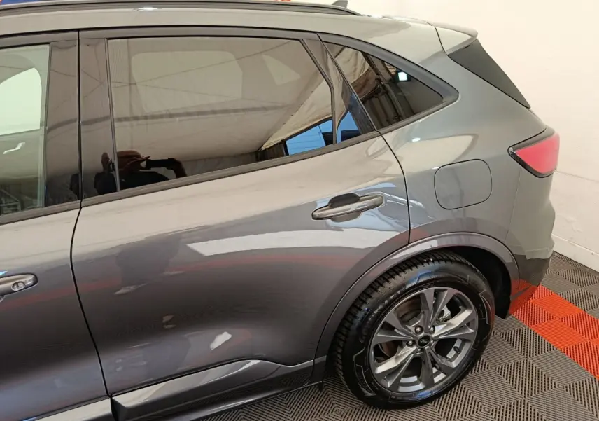 Vue latérale droite du Ford Kuga gris clair 2024 avec jante alliage et vitres teintées.