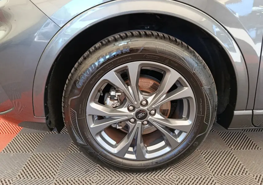 Gros plan sur la roue avant gauche gris clair du Ford Kuga 2.0 EcoBlue 2024 avec jante alliage et pneu Goodyear.