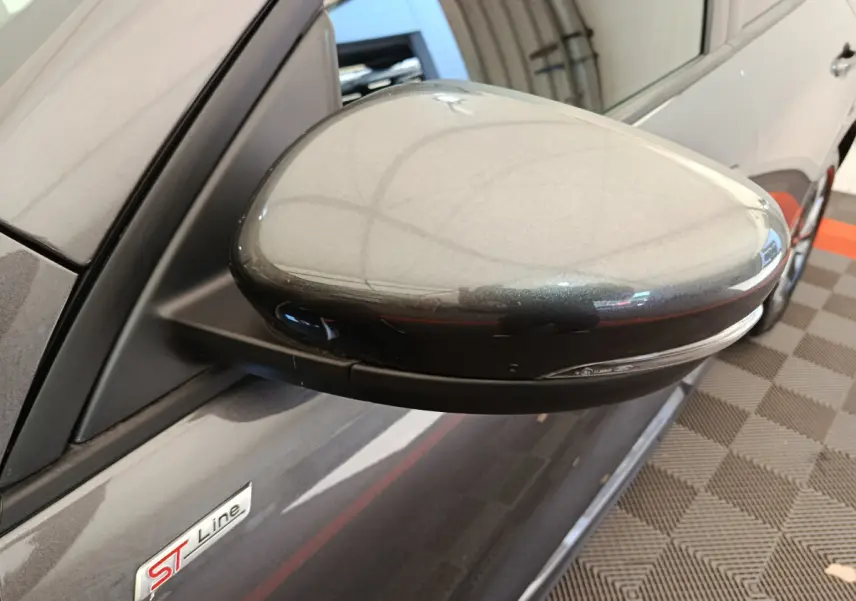 Gros plan sur le rétroviseur droit gris clair d'un Ford Kuga 2024 finition ST Line avec logo ST Line visible sur la portière.