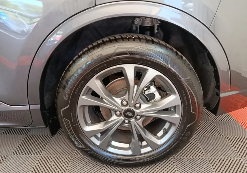Gros plan sur la roue avant droite gris clair du Ford Kuga 2.0 EcoBlue 2024 avec jante alliage et pneu Goodyear.