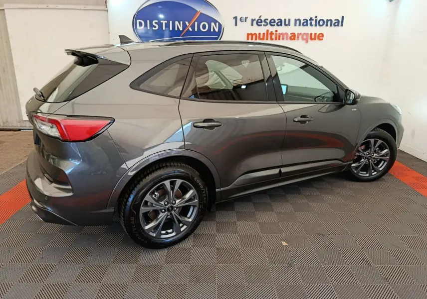 Vue latérale droite du Ford Kuga gris clair 2024 avec jantes alliage et vitres teintées en showroom.