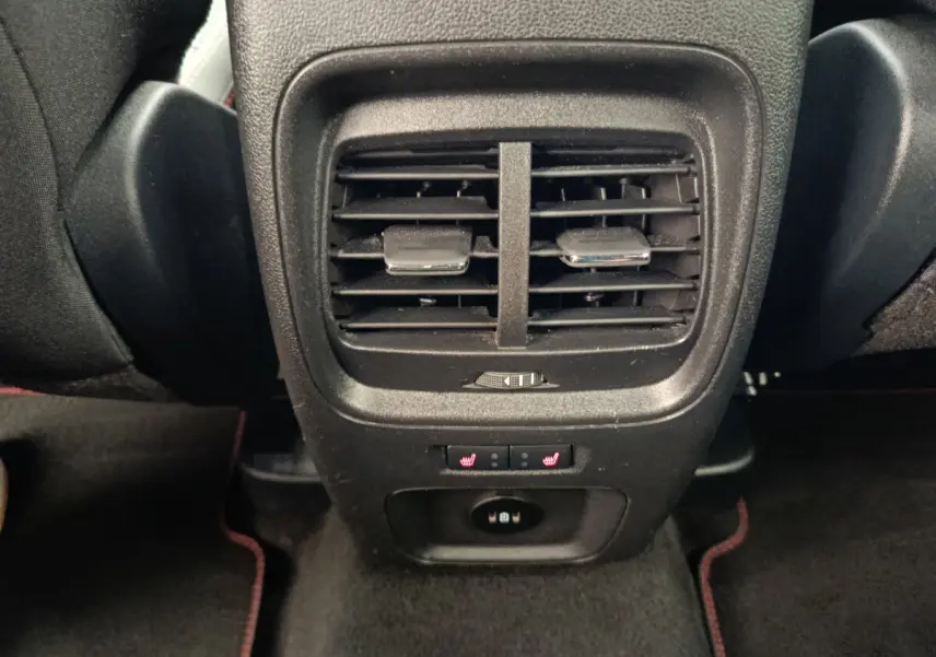 Vue rapprochée des aérateurs arrière et commandes de sièges chauffants du Ford Kuga 2.0 EcoBlue gris clair 2024.