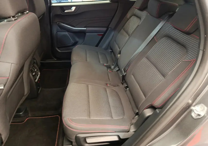 Vue intérieure côté droit des sièges arrière noirs avec surpiqûres rouges du Ford Kuga 2024 St Line.
