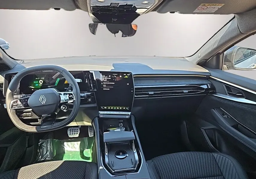 Vue avant de l’intérieur noir du Renault Austral blanc nacré, avec volant multifonction et écran tactile central vertical.